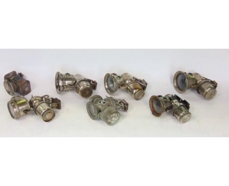 A box containing seven vintage motorcycle/cycle carbide lamps