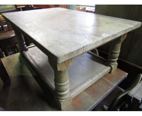 A traditional Old English oak occasional table of low form on four gun barrel supports.