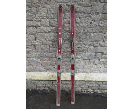 A pair of vintage wooden Tyrolia skis with painted finish, complete with metal fittings.
