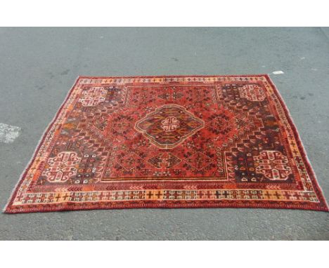 An Afghan floral carpet decorated with various medallions upon a red ground, 295 x 170 cm approx