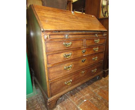 A Georgian mahogany bureau of three long and two short drawers with additional brush slide, the fall flap revealing a fitted 