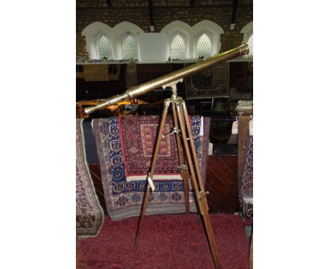 A contemporary brass telescope upon a telescopic tripod base.