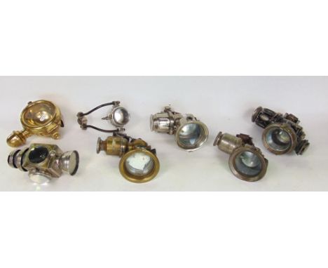 A box containing seven vintage motorcycle/cycle carbide lamps