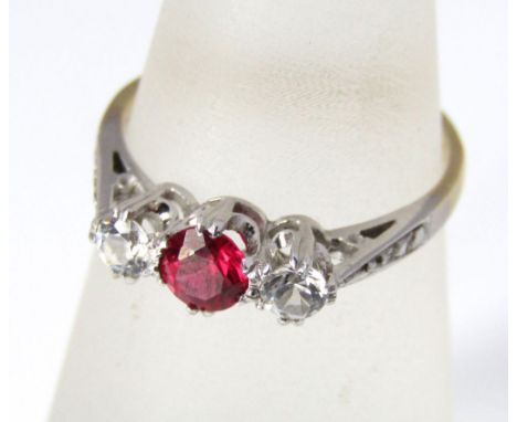 An 18ct and platinum three stone ring, with central ruby flanked by two white sapphires, size L/M, 2g