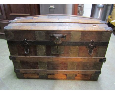 An Edwardian domed top trunk with timber lathes and partially fitted interior