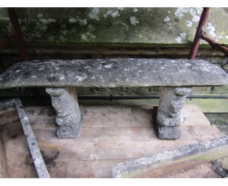 A weathered cast composition stone three sectional garden bench, the rectangular slab seat raised on a pair of column support