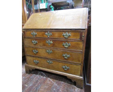 A Georgian oak country made bureau, the fall flap enclosing a fitted interior of drawers, pigeon holes and central cupboard o