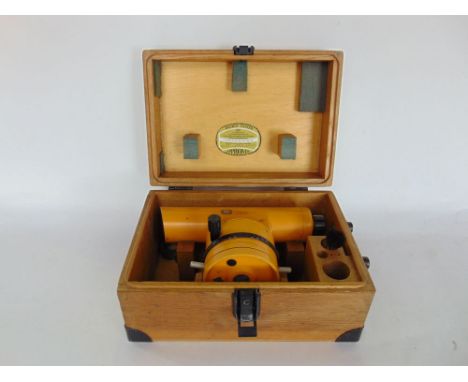 A Carl Zeiss theodolite, the scope in a branded wooden case upon an orange and galvanised steel tripod base.