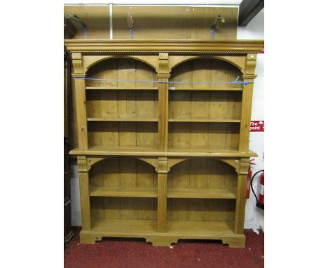 A stripped and waxed pine two sectional bookcase/display shelves with architectural mouldings and open two divisional fixed s