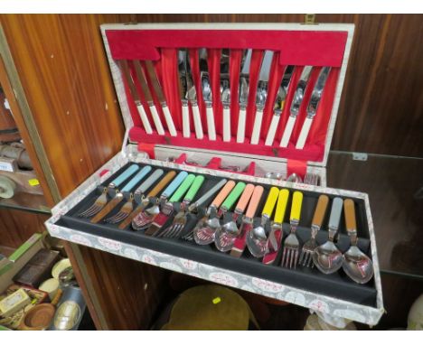 A CASED VINTAGE RETRO CUTLERY SET WITH MULTICOLOURED HANDLES TOGETHER WITH A CANTEEN OF CUTLERY (2)