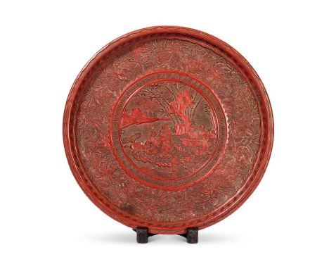 A Chinese circular cinnabar lacquer dish, Qing dynasty, carved in the 16th century style, with scholars and attendants seated