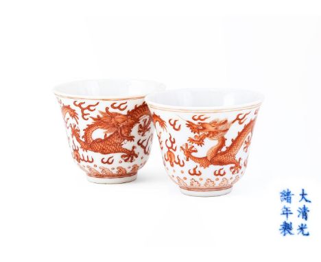 A pair of Chinese iron-red 'Dragon' cups, painted with two striding dragons pursuing flaming pearl amidst flaming clouds abov