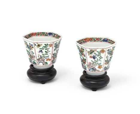A pair of Chinese Famille Verte hexagonal tea cups, Kangxi, 6cm high x 7.2cm diameter, fitted wood stands (2) Provenance:Priv