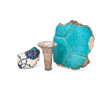 An Iznik pottery tile fragment, Ottoman Anatolia, 1570-80, depicting a stylised lotus flower, in blue, turquoise and red on w