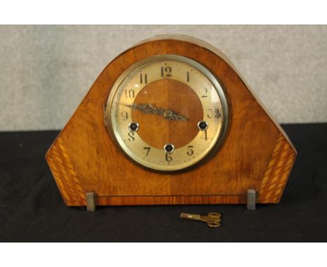 An Art Deco walnut cased mantle clock raised on shaped metal supports. H.23cm. 