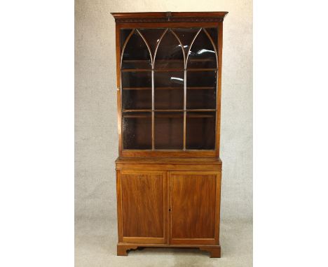 A 19th century mahogany bookcase with single glass panelled door above two cupboard door base opening to reveal shelf fitted 