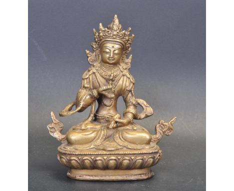 An early 20th century Chinese / Tibetan brass statue of the Buddha sitting cross legged raised on a lotus base. Signs of wear