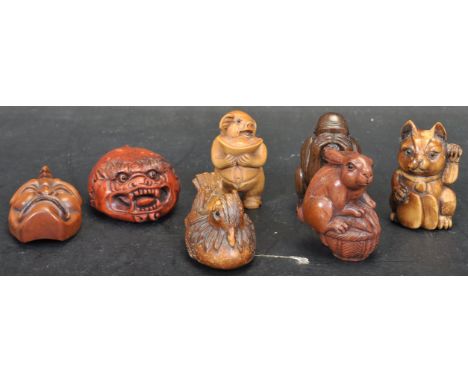 A group of seven Japanese oriental hand carved&nbsp;netsuke figurines to include a rabbit sitting on a basket with green eyes