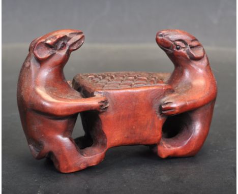 An early 20th century hard wood carved Japanese netsuke. The hand carved netsuke depicting two exotic animals sitting around 