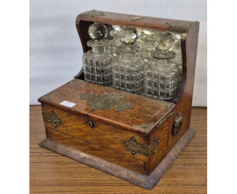 An early 20th Century oak and brass mounted tantalus 