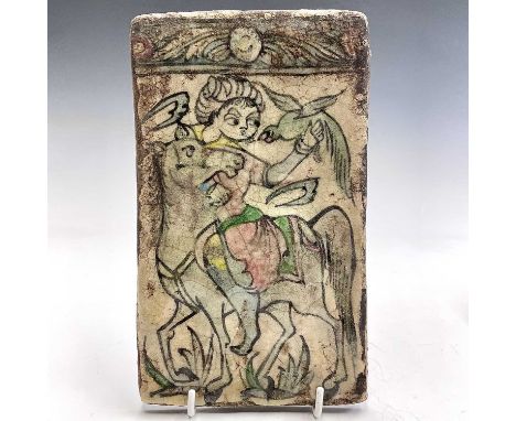 A Persian tin glazed pottery tile, 19th century, relief decorated with a horse, rider and bird of prey, 22 x 13cm.