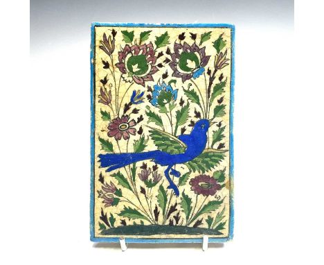 A Persian pottery tile, 19th century, decorated with a bird amongst flowers, 16.5 x 11cm.
