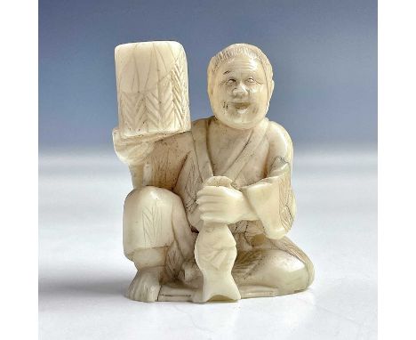 A Japanese ivory netsuke of a seated figure with a basket, 19th century, height 4cm, width 3cm.