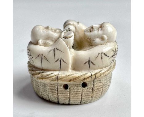 A Japanese ivory netsuke of two figures with a flask and cup, Meiji period, height 3cm, width 4cm, depth 3.5cm.