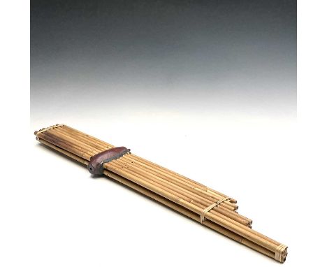 A Chinese bamboo and hardwood harmonica, length 88.5cm, width 10.5cm, depth 4cm.