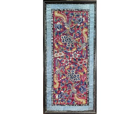 A Chinese silk embroidered panel, 19th century, the red ground decorated with stylised birds and moths amongst foliage, frame