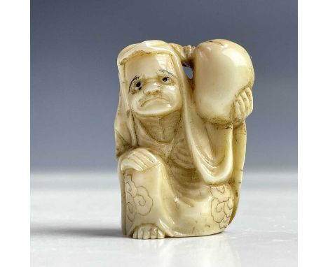 A Japanese ivory netsuke of a man holding a bag on his shoulder, Meiji period, height 3.5cm, width 2.5cm.