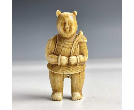 A Japanese ivory netsuke of a standing figure holding a palm leaf, late 18th/early 19th century, height 5cm, width 2.5cm.