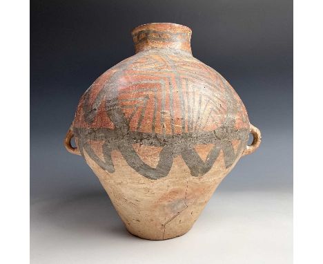 A Chinese Neolithic terracotta vase, with a tubular neck and two loop handles; the upper body painted with geometric motifs, 