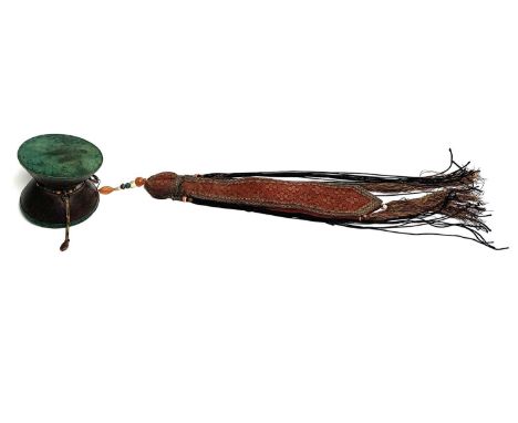 A Tibetan damaru drum, 19th century, the central silver band with coral and jade type stones, with beads and woven silk attac
