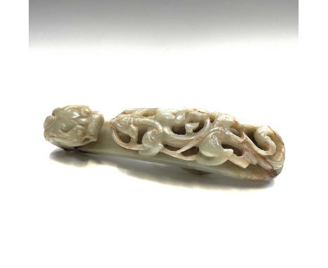 A Chinese jade belt hook, Qing Dynasty, carved with a scroll form chilong facing a dragon head terminal, circular whorl carve