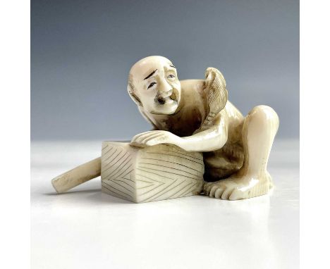 A Japanese ivory netsuke of a rat catcher, Meiji period, signed, with a rat on his shoulder, height 3cm, width 5cm.