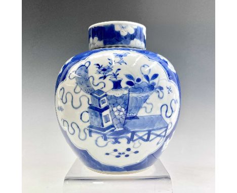 A Chinese blue and white ginger jar and cover, late 19th century, the prunus pattern body with opposing lobed panels enclosin