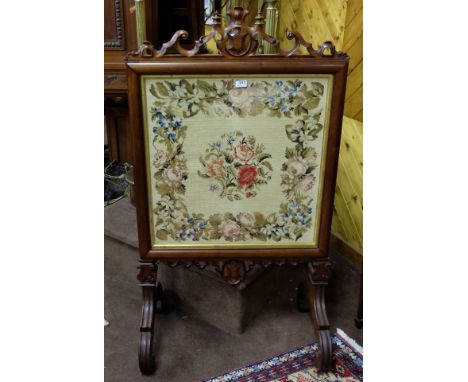 Victorian mahogany framed Fire Screen with carved decorative cartouche about a Berlin wool work floral panel, on 4 scrolled l