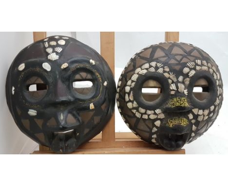 Pair of craved African Matrimonial Male and Female Masks, each 9”w x 9”h, decorated with shells and brass inlays, circular an