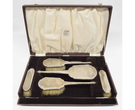 Boxed silver engine turned dressing table set, comprising a hand mirror, four brushes and comb holder, Birmingham 1939, maker