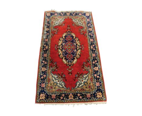 PERSIAN RUG WITH LARGE, OVAL CENTRE MEDALLION, with small pendants, plain crimson field, fancy floral spandrels, the principa