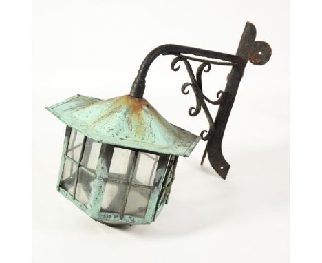 EXTERIOR CAST METAL AND COPPER(?) CORNER ELECTRIC LANTERN, of hexagonal form and with cast metal scroll bracket, 23“ (58.4cm)
