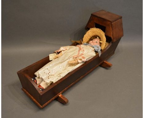 A German Bisque Head Doll with jointed limbs, together with a dolls cradle 