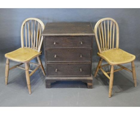 An Oak Chest of Three Drawers with knob handles raised upon bracket feet, together with a pair of elm Windsor side chairs 