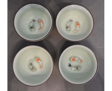 A Set of Four Chinese Porcelain Small Bowls, each decorated in relief with fish, 7.5cm diameter 