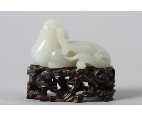 A Chinese carved jade mythical beast, on hardwood stand, 3" long