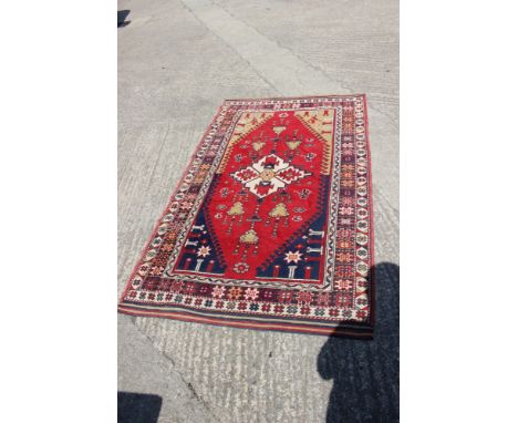 A pair of Konya tribal rugs with lamp design on a red ground and multi-star borders in shades of red, blue, green, buff and n