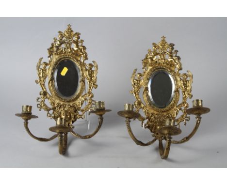 A pair of brass three-light girandoles with oval mirror plates, 15" high overall