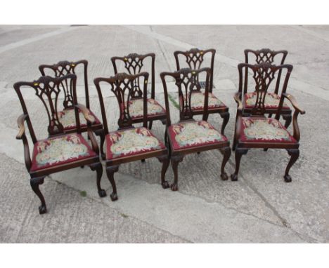 A set of eight carved mahogany Chippendale design dining chairs with pierced splat backs and needlework drop-in seats, on cab