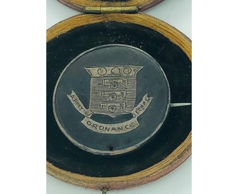 An Army Ordnance Corps silver and tortoise shell badge.